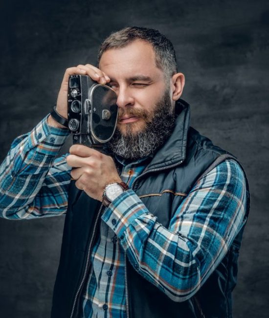 bearded-middle-age-male-holds-vintage-8-mm-video-camera-.jpg